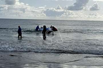 Una lancha neumática con varios jóvenes inmigrantes arriba a la playa de Ojos de Garza/TA.